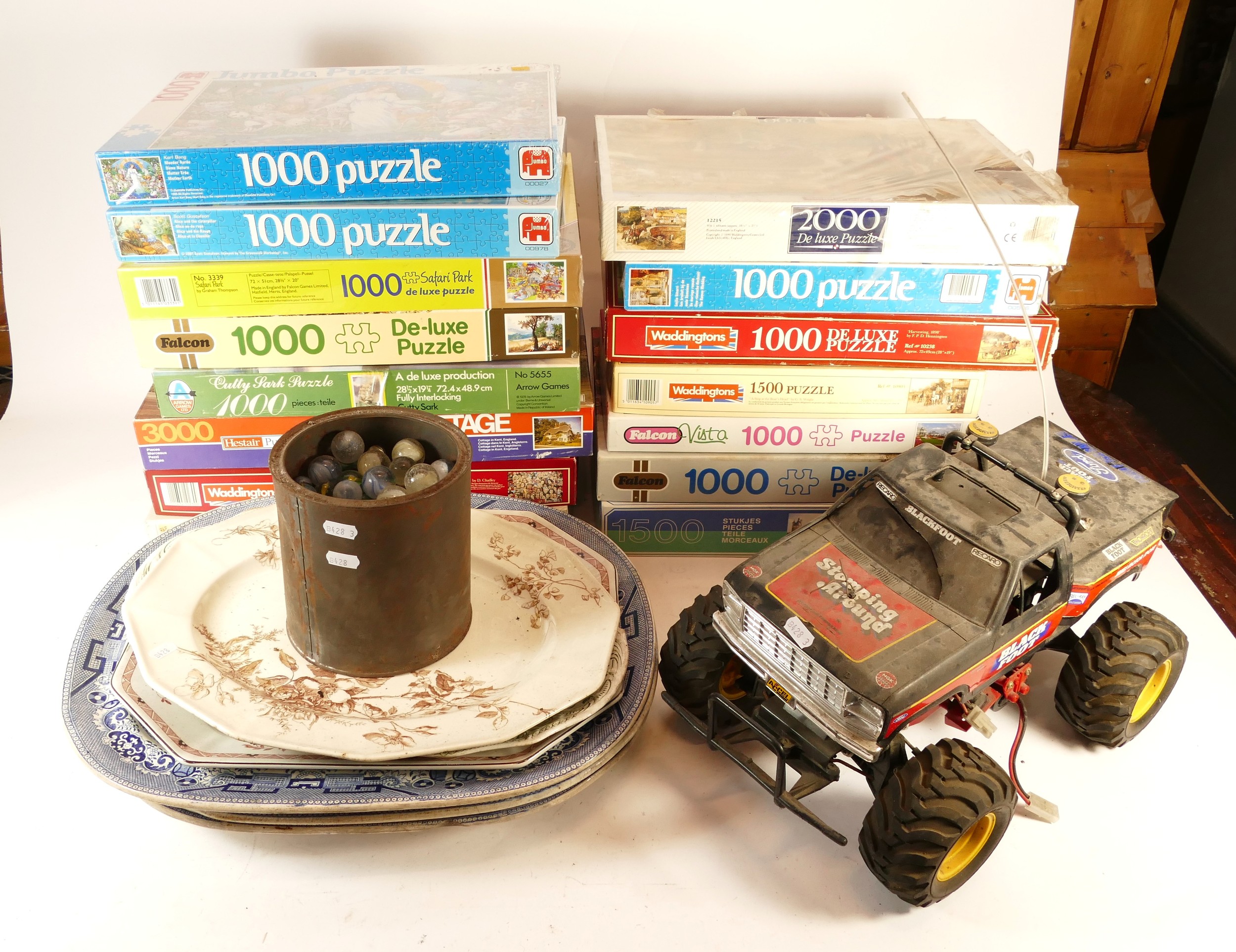 A collection of over 15 boxed jigsaw puzzles, together with a remote ...