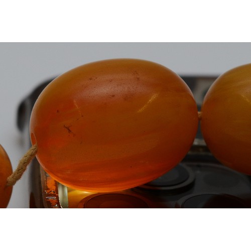 15 - A Bakelite beaded necklace. graduating bead size, largest 25mm, 78cm with two spare beads, 113g