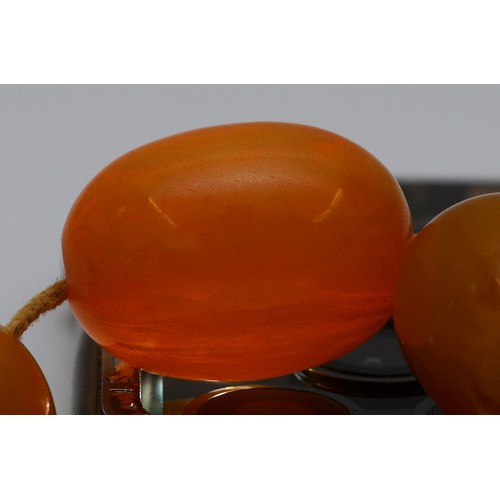 15 - A Bakelite beaded necklace. graduating bead size, largest 25mm, 78cm with two spare beads, 113g