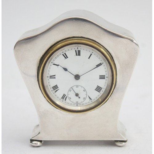 A silver desk clock, Birmingham 1912, by Joseph Gloster Ltd, having white enamel dial with subsidiary second dial and Roman numerals, pocket watch movement, having slight dint to the front, and dint to one of four ball feet, 8.5 x 8cm.