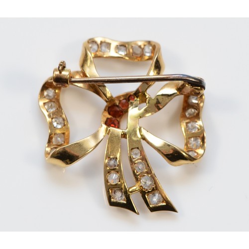 39 - An unmarked gold, garnet and white gemstone ribbon brooch, 27mm, 4g
