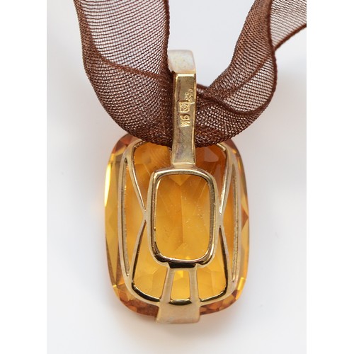 41 - A 9ct gold mounted orange gemstone on a ribbon necklace with a gold clasp, 4.9g