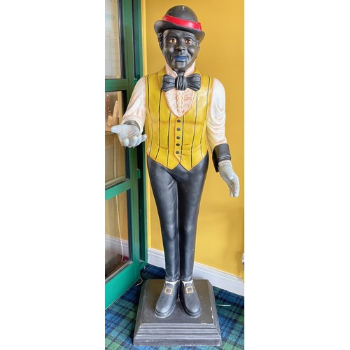 A hand painted fiberglass model of a man in yellow waistcoat holding his hand in greeting, 176cm