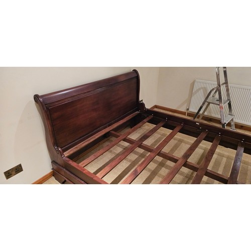 Late 20th-century mahogany Empire style king-size sleigh bed, scrolled panelled headboard, and footboard, base with moulded plinth raised on bracket feet.