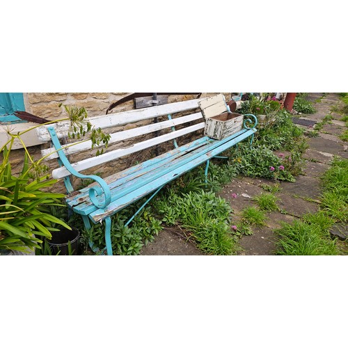 16 - A wrought iron garden bench with wooden slats.