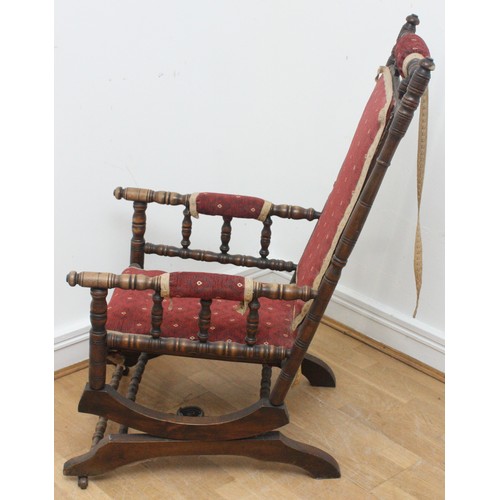 20 - An early twentieth century wooden rocking armchair, American style, with turned bobbin detail, raise... 