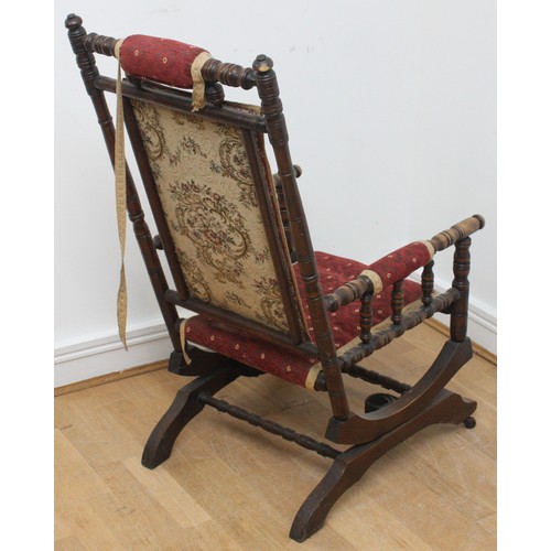 20 - An early twentieth century wooden rocking armchair, American style, with turned bobbin detail, raise... 