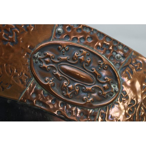 13 - A large oval mirror with a bevelled edge and a copper plated frame, in the style of the Arts and Cra... 