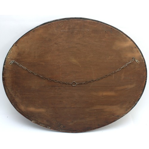 13 - A large oval mirror with a bevelled edge and a copper plated frame, in the style of the Arts and Cra... 