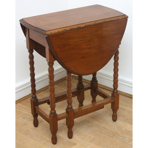 24 - An Edwardian oak drop-leaf side table, gateleg action  oval form top, supported on bobbin turned leg... 