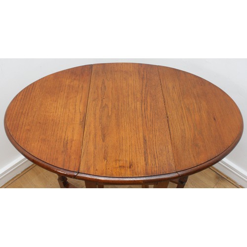 24 - An Edwardian oak drop-leaf side table, gateleg action  oval form top, supported on bobbin turned leg... 