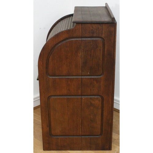 22 - An Edwardian oak roll-top desk, the tambour shutter enclosing interior with slide out writing surfac... 
