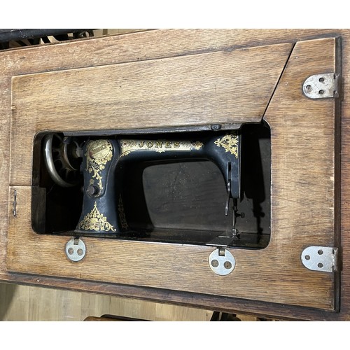 22 - Three early 20th century Jones and Singer treadle sewing machines, oak cased on cast iron frames, la... 