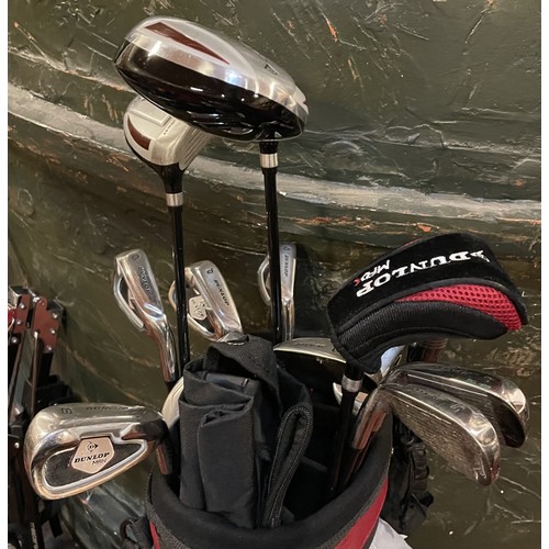 23 - A set of Dunlop Max golf clubs with a trolley, together with a bundle of trekking poles, umbrellas, ... 