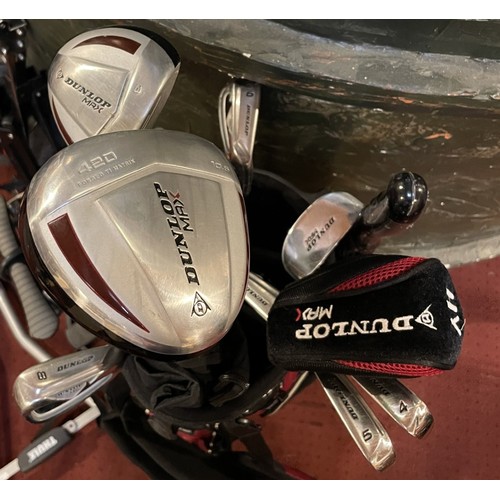 23 - A set of Dunlop Max golf clubs with a trolley, together with a bundle of trekking poles, umbrellas, ... 