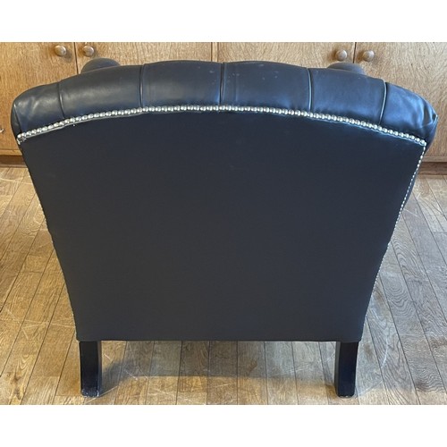 373 - A modern black leather armchair, having a Chesterfield inspired button back and stud detail, raised ... 