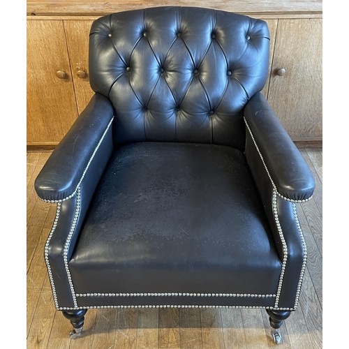 373 - A modern black leather armchair, having a Chesterfield inspired button back and stud detail, raised ... 
