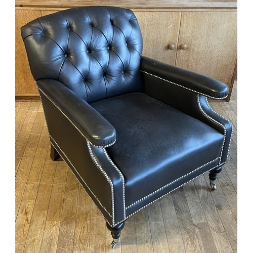373 - A modern black leather armchair, having a Chesterfield inspired button back and stud detail, raised ...