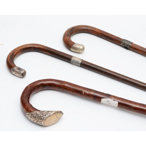 9 - Three wooden crook handled walking canes, having silver band to the tops, Birmingham 1897, 1871, Lon... 