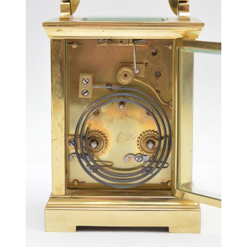 393 - A brass striking carriage clock, circular white enamel dial with Roman numerals, the eight day movem... 