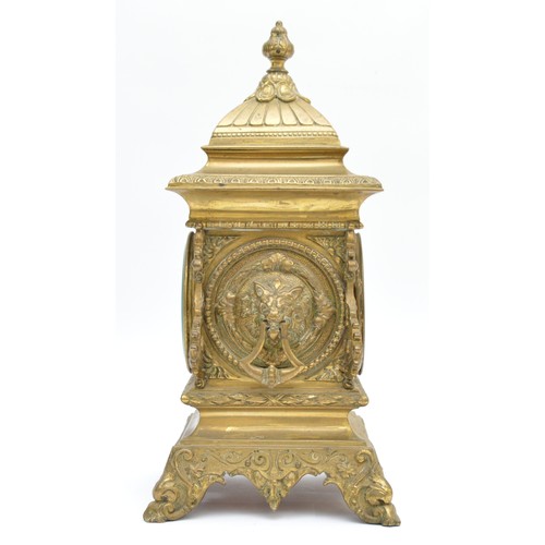 409 - A late 19th century French cast brass mantel timepiece, with lion mask handles, raised on scroll fee... 