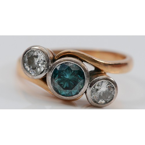 An 18ct gold three stone blue zircon and brilliant cut diamond crossover ring, London 1944, the central 7mm stone flanked by approximately 0.45cts stones, estimated G/H, VS2, Q 1/2, 6.6gm.