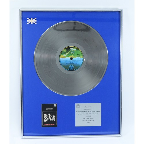 Thin Lizzy; original sales award, framed silver disc with blue felt baize, silver plaque to the lower right reading 'Certified BPI - Presented to THIN LIZZY. To recognise the sale, in the United Kingdom, of more than £150,000 worth of the VERTIGO Long Playing Album 'Bad Reputation' 1977', 51.5cm x 41.5.