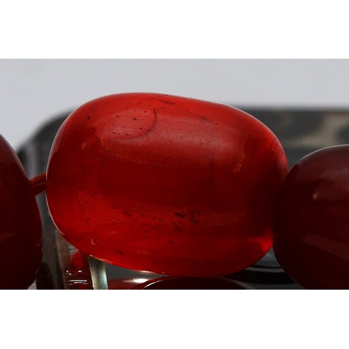 16 - A cherry Bakelite beaded necklace, graduated beads, largest 25mm, screw closure, 92cm, 90g