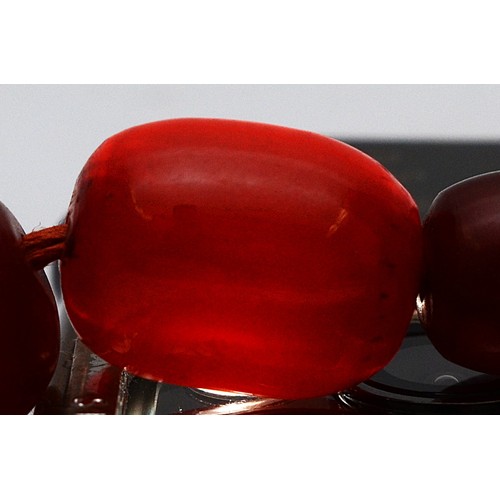 16 - A cherry Bakelite beaded necklace, graduated beads, largest 25mm, screw closure, 92cm, 90g