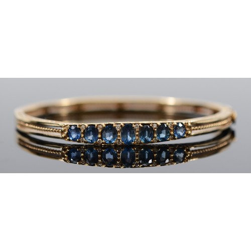 A 9ct gold brilliant cut diamond and sapphire hinged bracelet, largest sapphire is 6mm x 4mm, 15.3g