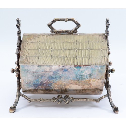A silver plated Victorian biscuit box, in the form of a cottage, with thatched roof that lifts at both sides when the handle is pulled, having cast floral branch stand and stamped with diamond registration mark dating 25th of September 1877, by Wilson & Davies,  17x19cm.