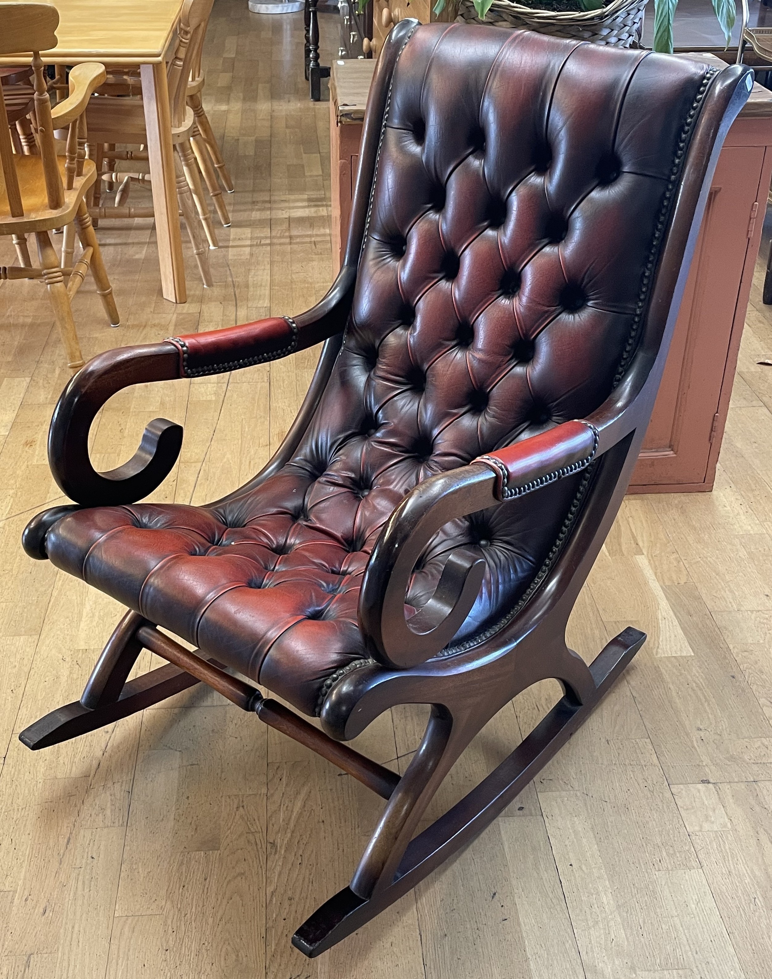 A Chesterfield style rocking chair, having deep buttoned oxblood ...