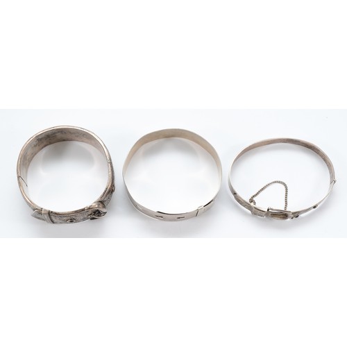 94 - A silver buckle bangle, Chester 1941, a silver buckle bangle with safety chain, Birmingham 1976, and... 