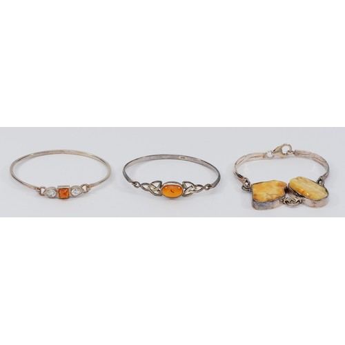 194 - Two silver and amber hinged bangles, with a 925 silver amber bracelet, 45g