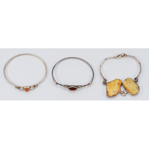 194 - Two silver and amber hinged bangles, with a 925 silver amber bracelet, 45g