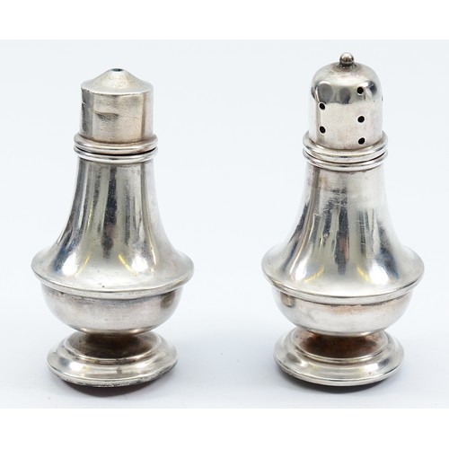 221 - A pair of silver salt and pepper pots, Birmingham 1933, on a rounded faux tortoiseshell base, 8cm, l... 