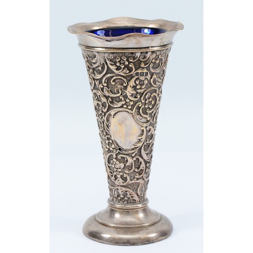 240 - A silver embossed trumpet vase, Birmingham 1903, by AE Goodby & Son, with blue glass liner, loaded,1... 