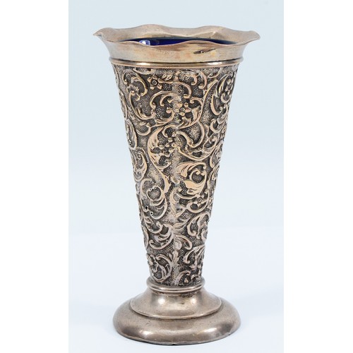 240 - A silver embossed trumpet vase, Birmingham 1903, by AE Goodby & Son, with blue glass liner, loaded,1... 