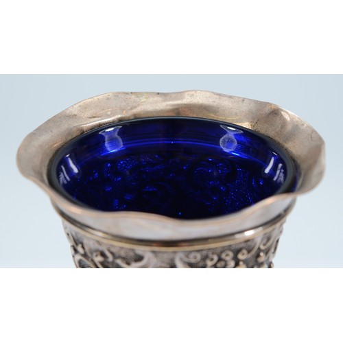 240 - A silver embossed trumpet vase, Birmingham 1903, by AE Goodby & Son, with blue glass liner, loaded,1... 