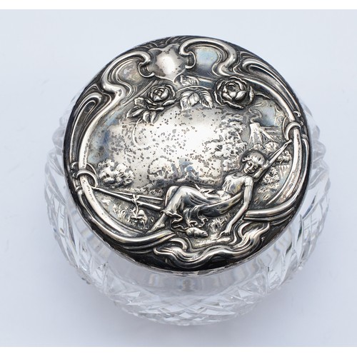 77 - A cut glass powder jar, with embossed silver lid of a lady in a hammock, marked sterling silver, lid... 