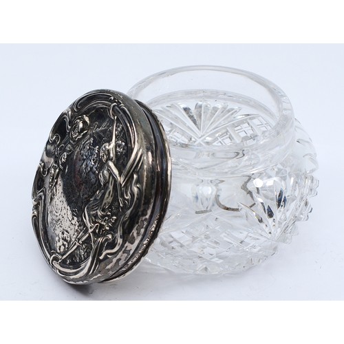 77 - A cut glass powder jar, with embossed silver lid of a lady in a hammock, marked sterling silver, lid... 
