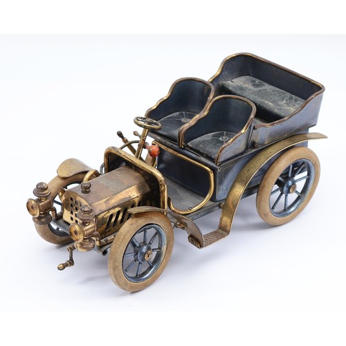 27 - A vintage brass and tin model of a brass era car cigarette container, green leather seats, lift up r... 