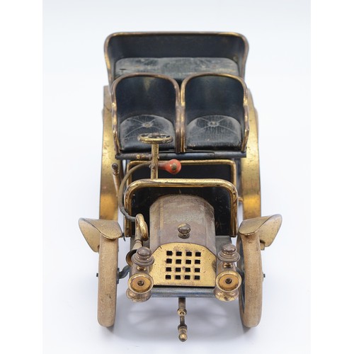 27 - A vintage brass and tin model of a brass era car cigarette container, green leather seats, lift up r... 