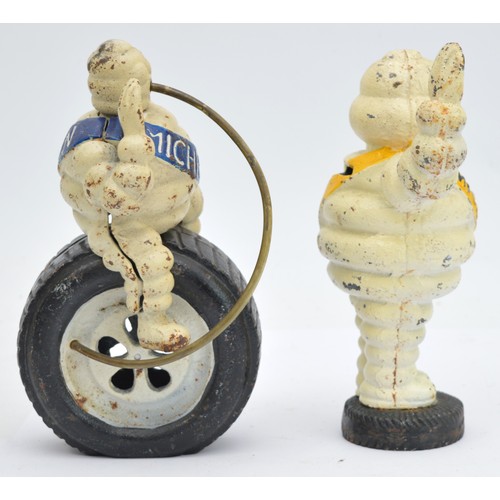 40 - A painted cast iron Michelin man riding a wheel, 24cm and another waving (2).