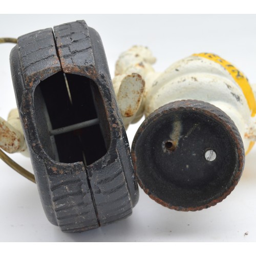 40 - A painted cast iron Michelin man riding a wheel, 24cm and another waving (2).