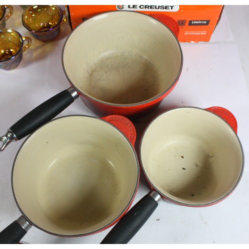 51 - A set of three Le Creuset sauce pans, a Le Creuset kettle and a selection of glassware.
