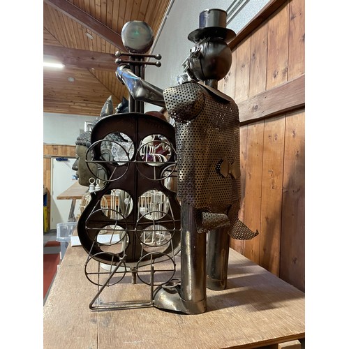 60 - A metal sculpture six bottle wine rack of a musician playing a cello 67.5cm high, a chrome five arm ... 