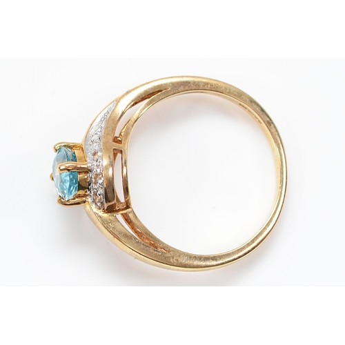16 - A 9ct gold brilliant cut diamond and blue topaz cross over ring, Birmingham 2007, N, 3g