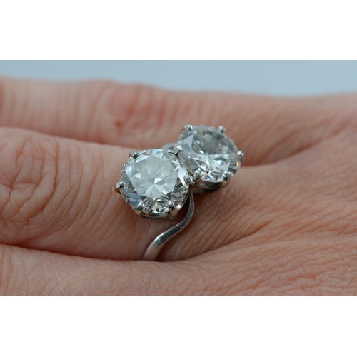  A circa 1940 unmarked platinum two stone cross over ring, two early brilliant cut diamonds weighed o... 