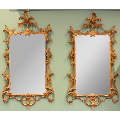 A pair of George III giltwood mirrors, with later plates, each carved with waved pierced rectangular frame, acanthus, foliage and scrolls, 113 x 63cm (2).